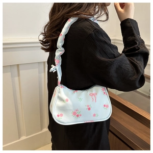 Détail du sac hobo bleu clair avec motifs de roses roses et bandoulière plissée