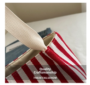 Close-up of red and white striped canvas tote showing durable stitching and cotton handle