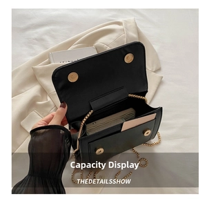 Detail view of black leather crossbody bag with dual magnetic buckles and phone storage