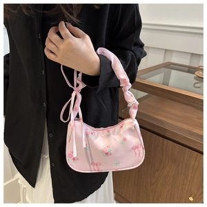 Detail of pink floral satin bag featuring bow prints and ruffled scrunchie handle