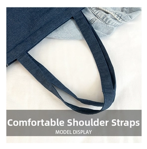 Detailed close-up of dark blue denim tote bag shoulder strap with reinforced stitching