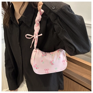 Detailed shot of pink floral shoulder bag with rose patterns and bow ribbon handles