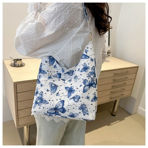 Gros plan d'un sac cabas rétro à imprimé papillon porté par un mannequin pour le style