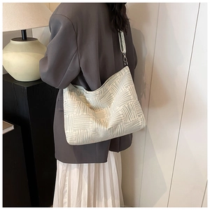 Detailed view of striped oversized tote bag with 3D texture and wide shoulder strap