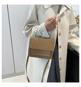 Detailed view of vintage crossbody bag with pearl handle and letter pattern print