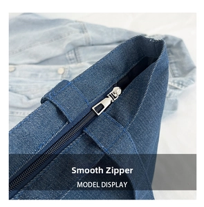 Detail of smooth metal zipper closure on deep blue denim tote bag for women