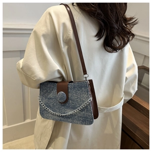 Détail du petit sac carré bleu pailleté avec bandoulière en cuir marron et chaîne argentée