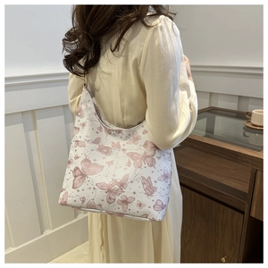 Détail du sac cabas blanc avec imprimés papillons roses et poche latérale pratique
