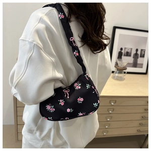 Vue détaillée du sac sous le bras en nylon à motifs de roses roses et de nœuds papillon
