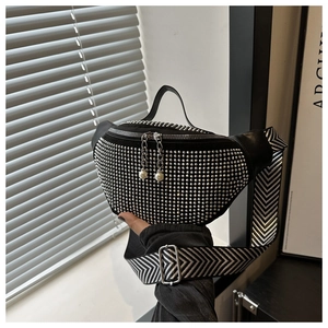 Détail du sac banane noir avec rivets argentés et pendentif perle sur le zip