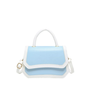 Blue and white minimalist crossbody bag with top handle and gold hardware on white background