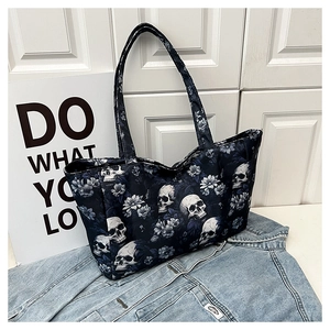 Detail of large tote bag with skull and blue floral patterns on dark navy canvas