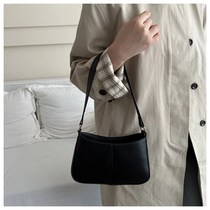 Détail d'un sac sous les aisselles minimaliste en similicuir noir avec coutures verticales