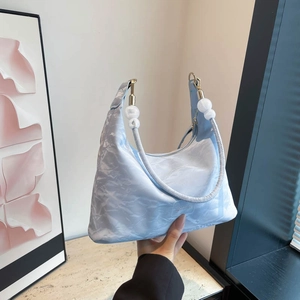 Light blue slouchy tote bag with pleated texture and stylish white beaded shoulder strap