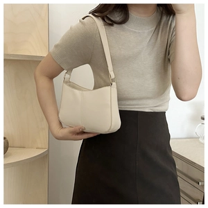 Détail du sac bandoulière blanc crème avec des boucles en métal doré poli