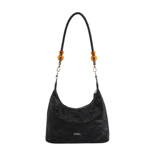 Minimalist black soft leather tote bag with unique orange beaded strap detail