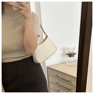 Sac à bandoulière en cuir blanc avec coutures verticales montré dans un selfie miroir chic