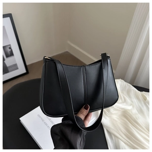 Détail du sac sous l'aisselle noir mat avec double couture et boucle dorée
