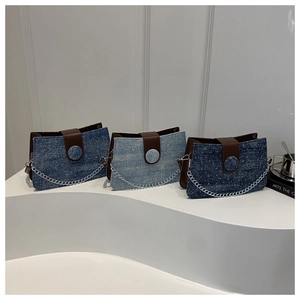 Detailed close-up of three blue denim tote bags with silver chains and leather flaps