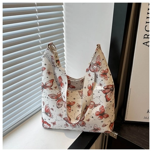 Détail de l'imprimé papillon et constellation sur tote bag blanc avec rivets métalliques
