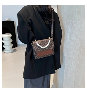 Close-up of retro letter print crossbody bag with luxury pearl chain and contrast splicing