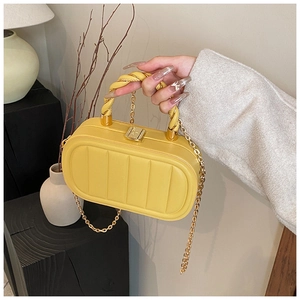 Detail of yellow box bag with vertical ribbing texture and twisted handle