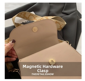 Detailed close-up of the metal magnetic clasp on a beige PU leather crossbody bag