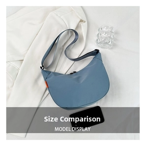 Detailed size comparison of Morandi blue nylon crescent bag with orange accent tag