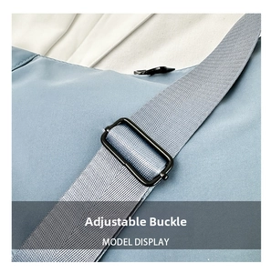Detail of adjustable strap with matte black metal buckle on a light blue oxford bag