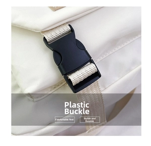 Dettaglio della fibbia in plastica nera e della tracolla intrecciata su borsa bianca
