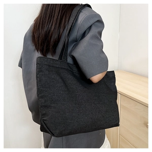 Minimalist black tote bag shown on model highlighting spacious rectangular design