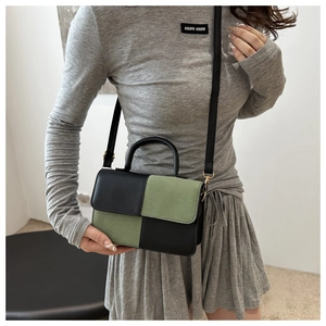 Dettaglio borsa retrò bicolore con pelle scamosciata verde e cuciture in pelle nera