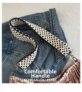 Close-up of wide striped canvas strap with silver metal buckle on denim jacket