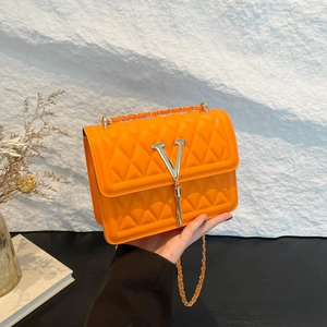 Chic orange quilted crossbody bag with chain strap and V-shaped tassel detail