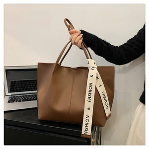 Vue détaillée du sac cabas marron avec ruban tendance dans un décor de bureau chic