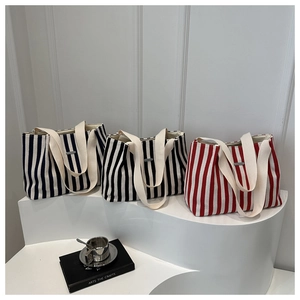 Detailed row of large canvas tote bags with blue, black, and red vertical stripes