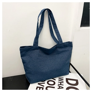 Detail of dark blue denim tote bag showing twill fabric texture and long shoulder straps