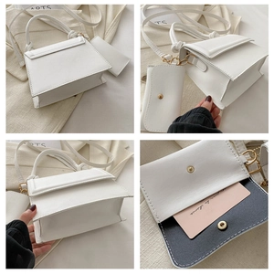Detail view of white leather crossbody bag with top handle and matching mini card pouch