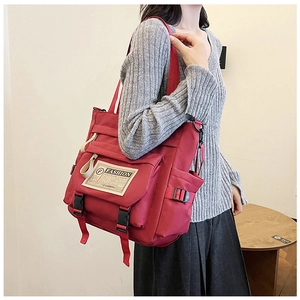 Vista dettagliata della borsa a tracolla rossa in nylon con fibbia e toppa fashion