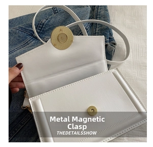 Detail of white PU leather flap bag featuring gold hardware magnetic clasp and fine stitching