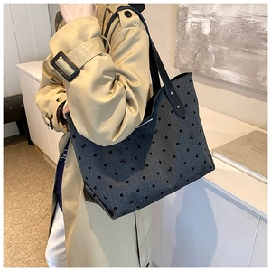 Close-up of a large polka dot tote bag with black bow detail and leather handles