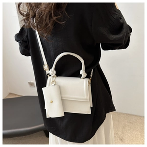 Rear view of a minimalist white crossbody square bag with mini pouch and knotted handle