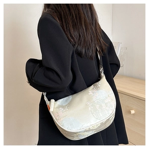 Detail of silk jacquard crescent bag with traditional Chinese patterns on black blazer
