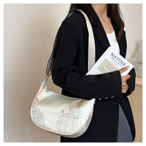 Detailed view of silk jacquard crescent bag with traditional Chinese floral patterns