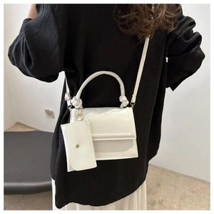 Détail du sac bandoulière blanc minimaliste avec poignée nouée et petit porte-monnaie