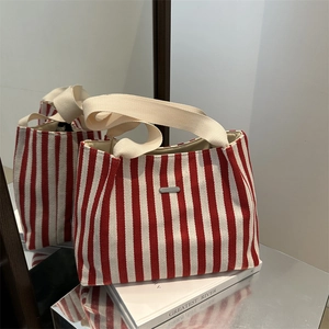 Large red striped canvas tote bag with off-white handles and silver metal plate for women