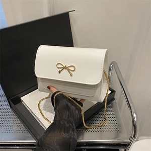 Chic white leather shoulder bag with gold bow buckle and chain strap for women