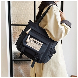 Dettaglio della borsa messenger in nylon nero con tasca laterale a coulisse e fibbie