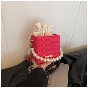 Détail du sac à main fuchsia à damier avec grande poignée en perles et cordon de serrage
