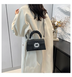 Detail showing the black crocodile pattern bag worn on body with a crossbody strap